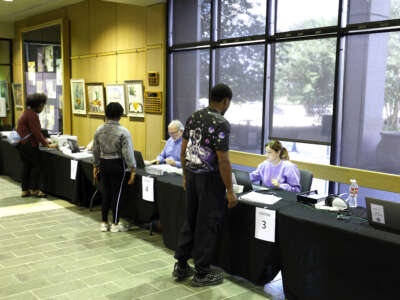 Voters check in before casting their ballots on the first day of early voting at the Louisiana State Archives on May 2, 2026, in Baton Rouge, Louisiana.