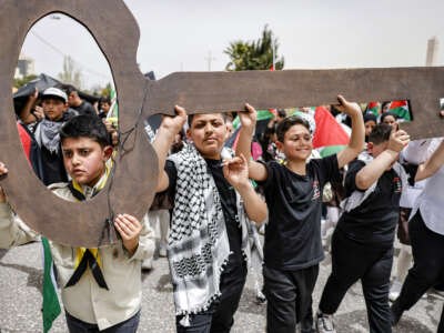Boys march with a figure depicting a traditional key symbolizing the homes that Palestinians evacuated in 1948 during the Nakba, their 1948 displacement by Zionist militias during the creation of Israel, during a march commemorating the 78th anniversary of the catastrophic event in the city of Ramallah in the occupied West Bank, on May 12, 2026.
