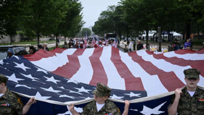 Members of the "Young Marines" youth program carry a large American flag during the National Memorial Day Parade on Constitution Avenue in Washington, D.C., on May 25, 2026.