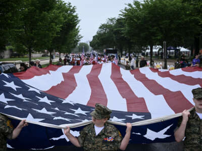 Members of the "Young Marines" youth program carry a large American flag during the National Memorial Day Parade on Constitution Avenue in Washington, D.C., on May 25, 2026.