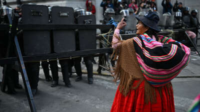 An Indigenous woman gestures in front of riot police during a protest against the government of President Rodrigo Paz on Mother's Day in La Paz, Bolivia, on May 27, 2026.