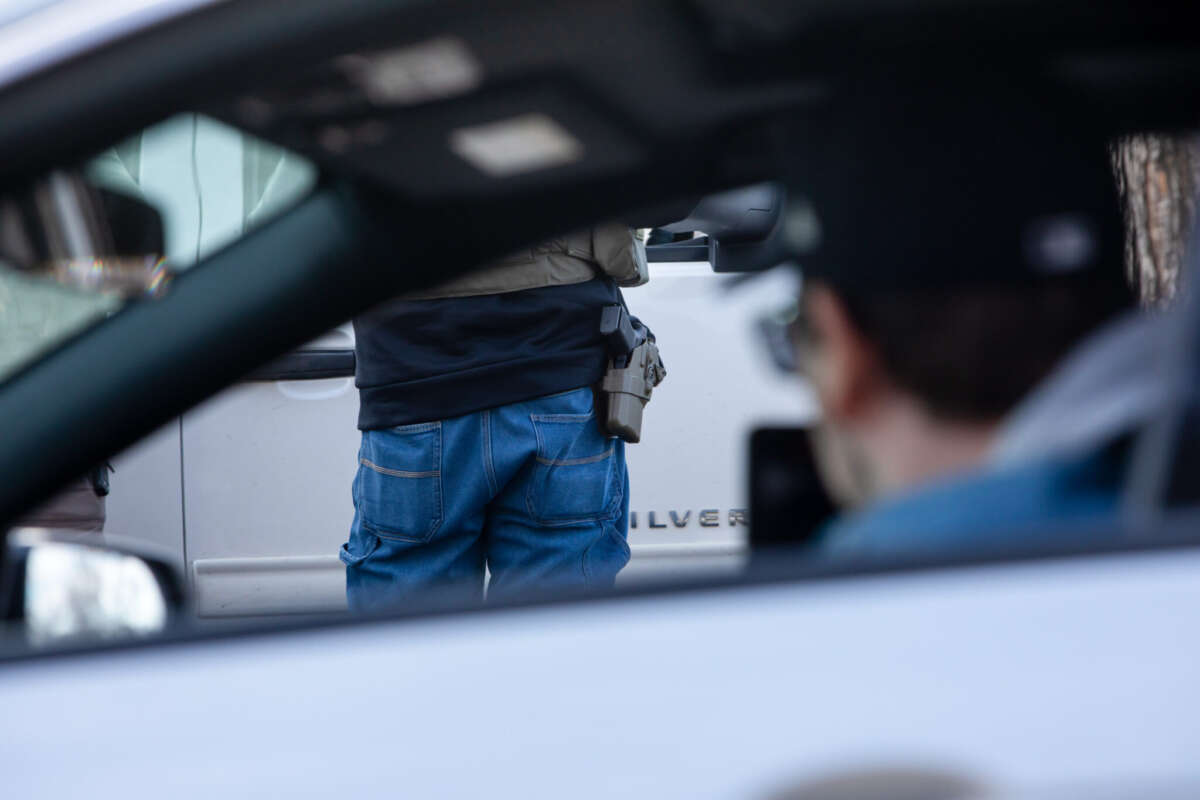 An observer films as armed ICE agents arrest two men during a traffic stop on February 11, 2026, in Robbinsdale, Minnesota.