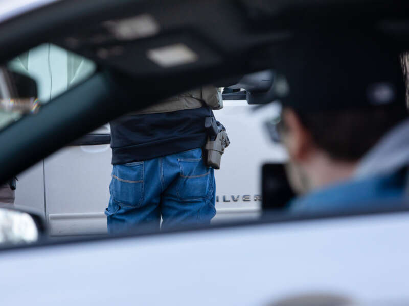 An observer films as armed ICE agents arrest two men during a traffic stop on February 11, 2026, in Robbinsdale, Minnesota.