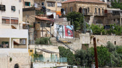 A pair of eyes looks out over the Al-Bustan valley, part of a collection of murals painted by activists protesting the demolitions and evictions, on May 13, 2026.