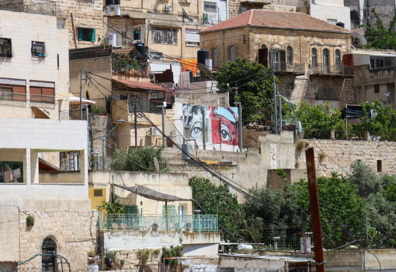A pair of eyes looks out over the Al-Bustan valley, part of a collection of murals painted by activists protesting the demolitions and evictions, on May 13, 2026.