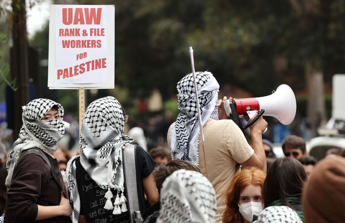 Pro-Palestinian protestors gather with a sign reading 'UAW Rank-and-File Workers For Palestine' after police cleared a new encampment of pro-Palestinian protestors on the UCLA (University of California, Los Angeles) campus on May 23, 2024 in Los Angeles, California.