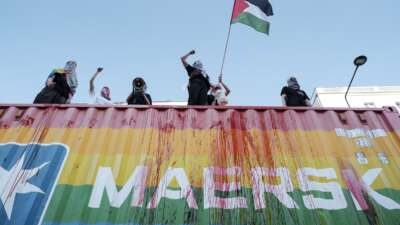Pro-Palestinian protesters block a Maersk container during the Warsaw Equality Parade in Warsaw, Poland, on June 14, 2025, accusing the company of transporting arms for Israel.