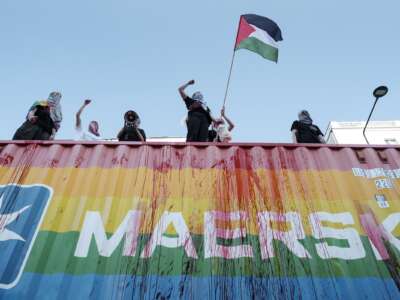 Pro-Palestinian protesters block a Maersk container during the Warsaw Equality Parade in Warsaw, Poland, on June 14, 2025, accusing the company of transporting arms for Israel.