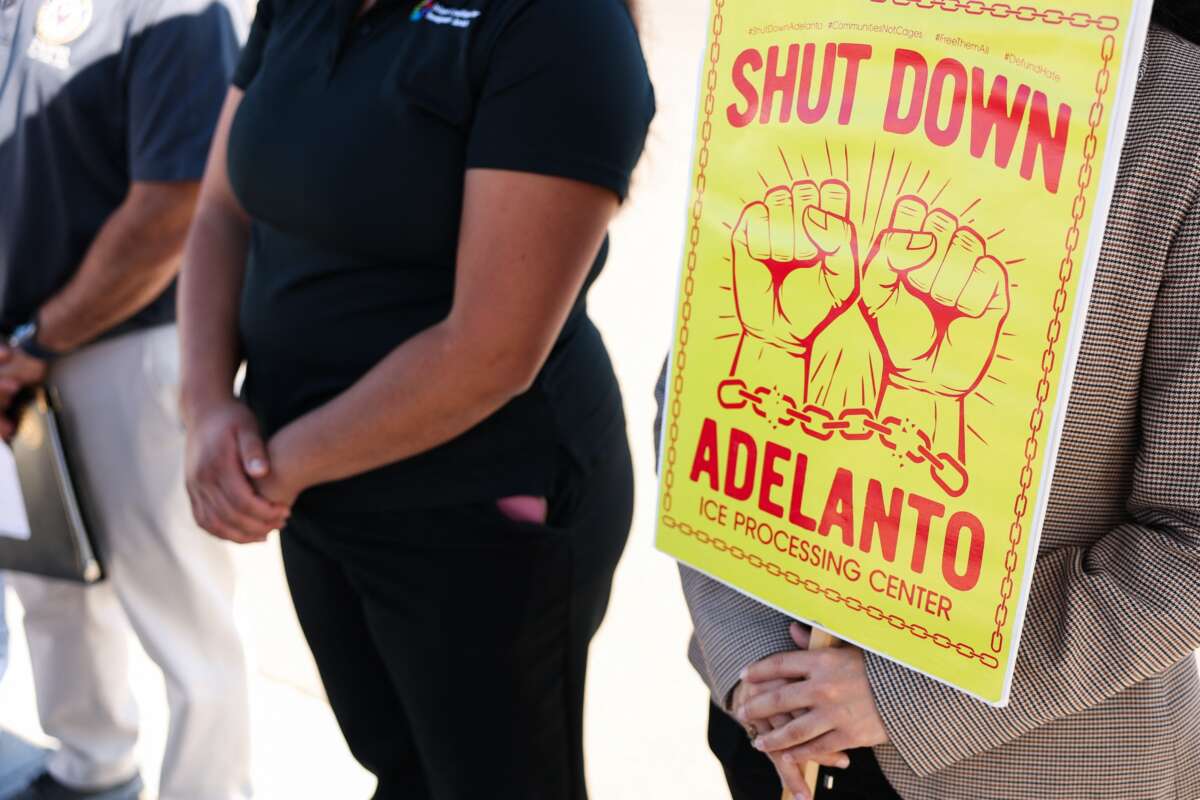A person holds a sign reading "Shut Down Adelanto" after US Representatives Raul Ruiz (D-CA) and Norma Torres (D-CA) were denied entry for a congressional oversight visit to the GEO Group Adelanto ICE Processing Center detention facility in Adelanto, California on July 11, 2025.