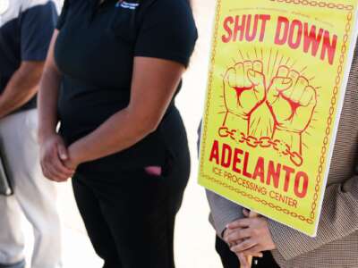 A person holds a sign reading "Shut Down Adelanto" after US Representatives Raul Ruiz (D-CA) and Norma Torres (D-CA) were denied entry for a congressional oversight visit to the GEO Group Adelanto ICE Processing Center detention facility in Adelanto, California on July 11, 2025.