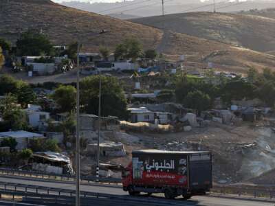 A truck drives past the Palestinian Bedouin village of Khan al-Ahmar occupied West Bank on May 20, 2026. Khan al-Ahmar sits near land Israel plans to use for its E1 development project that would facilitate settlement expansion in the area near Jerusalem; the village is facing an imminent threat of demolition and forced displacement.