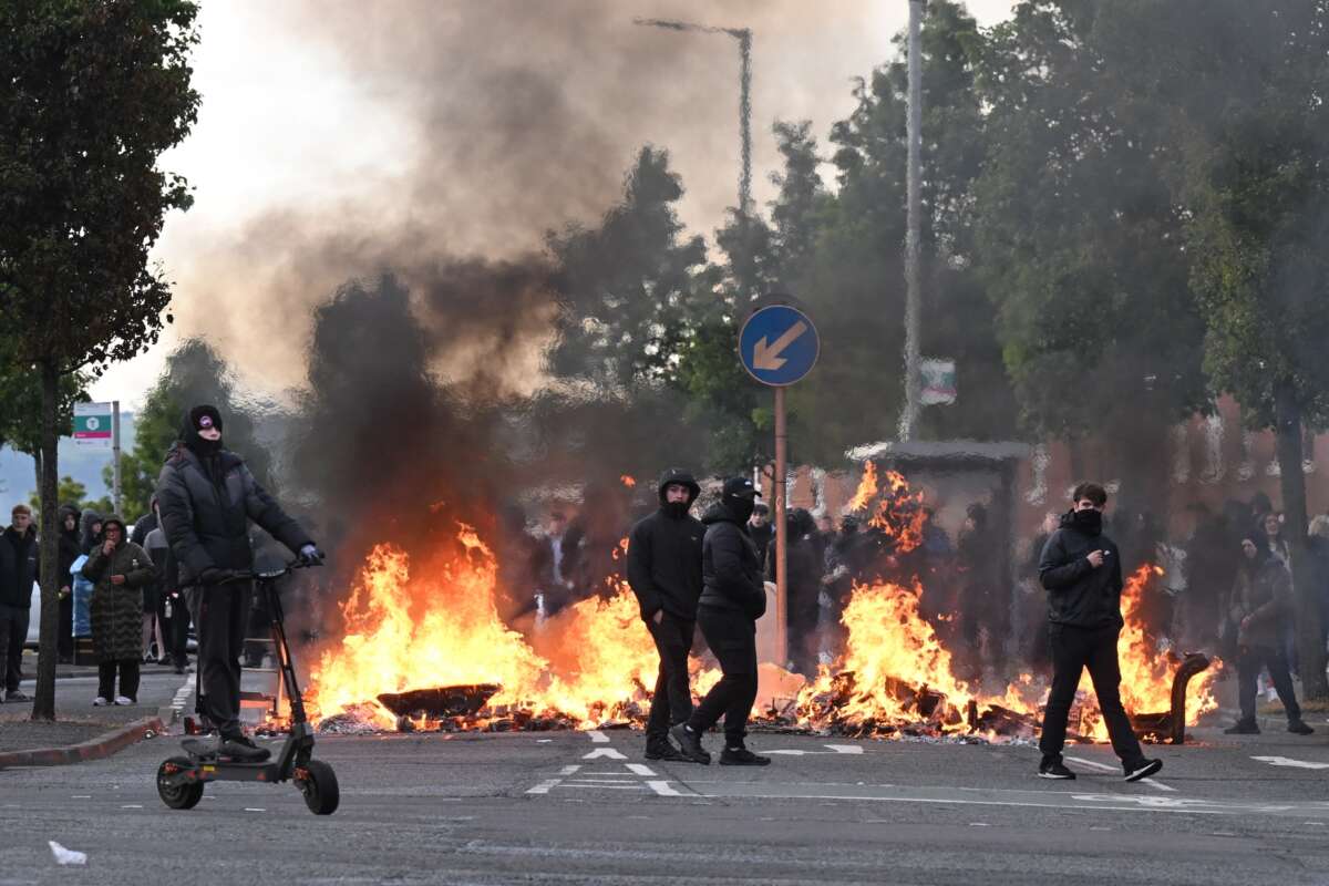 Masked young men set fires and targeted immigrants and people of color in Belfast, Northern Ireland, on June 9, 2026, after word of a knife attack circulated online along with right-wing calls that blamed migrants.