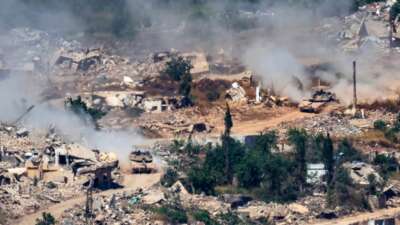 Israeli Merkava tanks drive along a road past destroyed buildings in southern Lebanon on June 17, 2026.