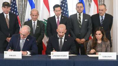 US Secretary of State Marco Rubio (C, back) looks on as (L/R, front row) Israeli Ambassador to the US Yechiel Leiter, State Department Chief of Staff Daniel Holler, and Lebanese Ambassador to the US Nada Hamadeh sign a framework agreement at the US Department of State in Washington, DC, on June 26, 2026.
