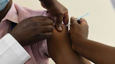 A Kenyan health worker receives a dose of the Oxford/AstraZeneca vaccine, part of the COVAX mechanism by GAVI, The Vaccine Alliance, to fight against COVID-19 at the Kenyatta National Hospital in Nairobi, Kenya, on March 5, 2021.