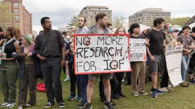 A pro-Palestine protester holds a placard that says, "No more research for IOF (Israeli Occupation Forces)" during a 2024 rally at the Massachusetts Institute of Technology (MIT) campus as student demonstrators demand divestment from Israeli military ties.