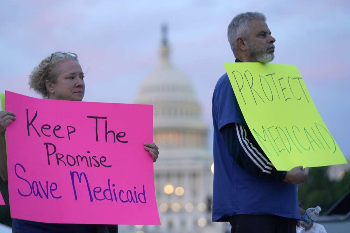 Protesters hold signs to protect Medicaid on May 7, 2025, in Washington, D.C.