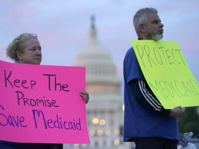 Protesters hold signs to protect Medicaid on May 7, 2025, in Washington, D.C.