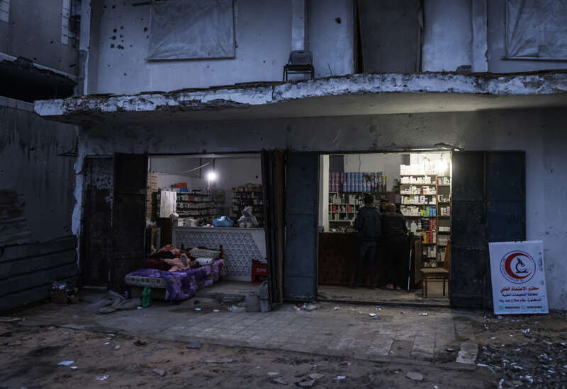 Men stand at the counter of a pharmacy in the Al-Saftawi neighborhood, west of Jabalia city in the northern Gaza Strip on December 10, 2025.