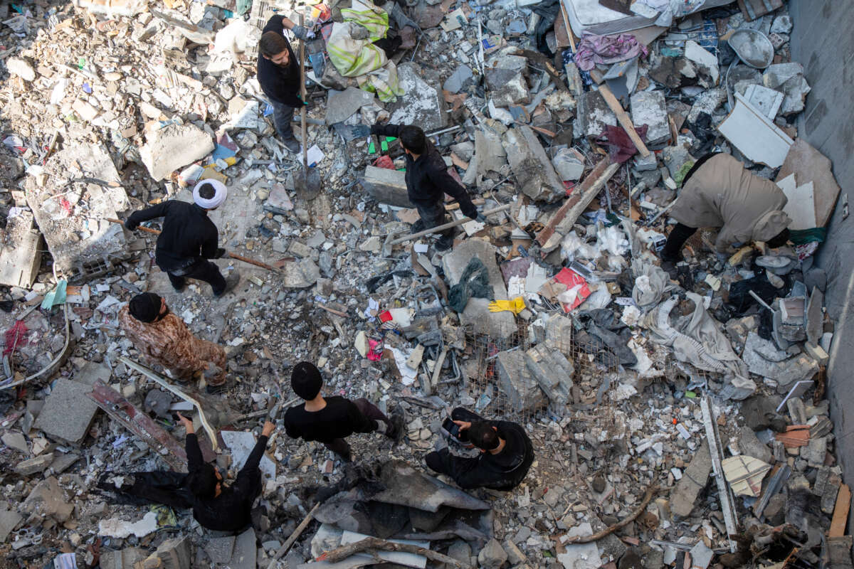 People sift through rubble in the aftermath of a drone attack on a residential building in which one civilian was killed on March 31, 2026, in eastern Tehran, Iran.