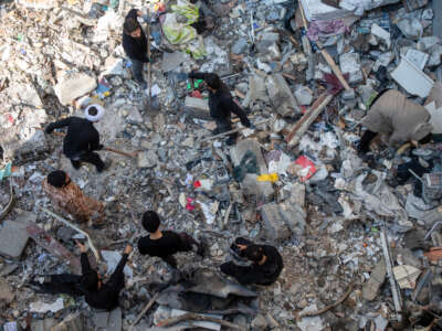 People sift through rubble in the aftermath of a drone attack on a residential building in which one civilian was killed on March 31, 2026, in eastern Tehran, Iran.