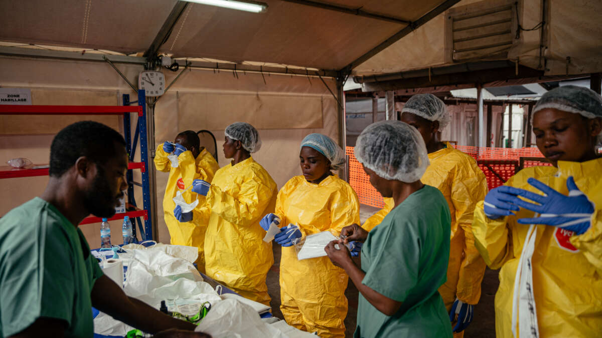 Health care workers put on personal protective equipment before going to examine patients at the Ebola Treatment Center in Munigi, Democratic Republic of the Congo, on June 2, 2026.