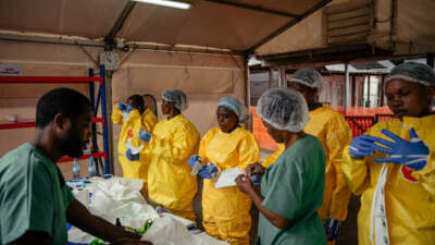 Health care workers put on personal protective equipment before going to examine patients at the Ebola Treatment Center in Munigi, Democratic Republic of the Congo, on June 2, 2026.