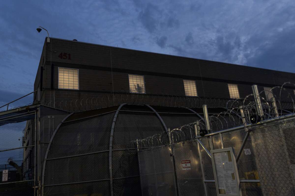 As part of a nightly tradition, imprisoned immigrants greet immigration activists from windows as ICE agents and pro-immigration activists face off outside the Delaney Hall Immigration Detention Center on May 27, 2026, in Newark, New Jersey.