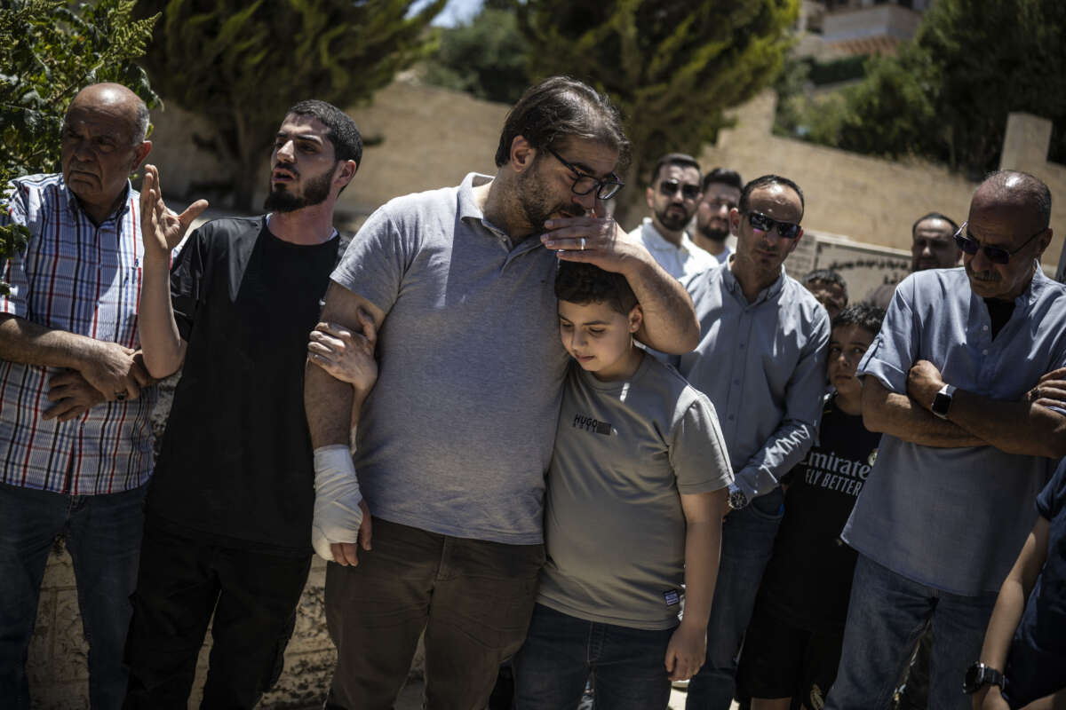 Fahd Abou Haikal comforts his elder son Kinan Abou Haikal after burying his seven-month-old baby Sam Fahd Abou Haikal, in Hebron, in the occupied West Bank, on June 6, 2026.