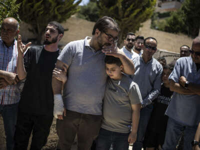 Fahd Abou Haikal comforts his elder son Kinan Abou Haikal after burying his seven-month-old baby Sam Fahd Abou Haikal, in Hebron, in the occupied West Bank, on June 6, 2026.