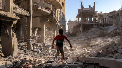 A boy walks through the rubble of a building that was destroyed following Israeli bombardment at the Maghazi camp for Palestinian refugees in the central Gaza Strip, on June 12, 2026.