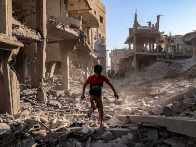 A boy walks through the rubble of a building that was destroyed following Israeli bombardment at the Maghazi camp for Palestinian refugees in the central Gaza Strip, on June 12, 2026.