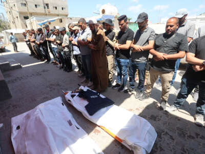 Friends and relatives of Al Jazeera video journalist Ahmed Wishah, who was killed in an Israeli strike the previous day, pray over his body at Al-Aqsa Martyrs Hospital in Deir el-Balah in the central Gaza Strip on June 21, 2026. The Israeli military said that Ahmed Wishah was killed alongside two other Hamas militants and that he had served as a "operative in Hamas's military wing," but did not provide any evidence to support the accusation.