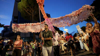 Protestors carry a giant sculpture of a flamingo as they demonstrate in front of the Albanian Prime Minister's Office against the construction on the southern coast of Albania a luxury resort near a protected natural area, in Tirana, Albania, on June 22, 2026.