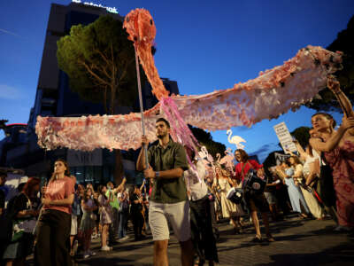Protestors carry a giant sculpture of a flamingo as they demonstrate in front of the Albanian Prime Minister's Office against the construction on the southern coast of Albania a luxury resort near a protected natural area, in Tirana, Albania, on June 22, 2026.
