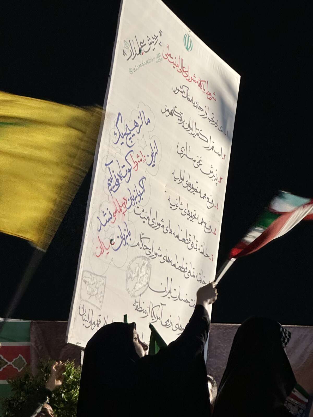 People hold a sign stating the 10 conditions for an agreement with the U.S. set by Iran's National Security Council.