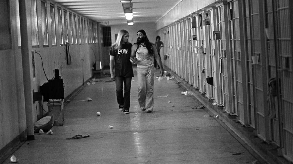 Men Against Sexism member Ed Mead walks with his lover, Danny Atteberry, through the Intensive Security Unit at Walla Walla State Penitentiary in the late 1970s during the one hour a day when they were allowed out of their cells.