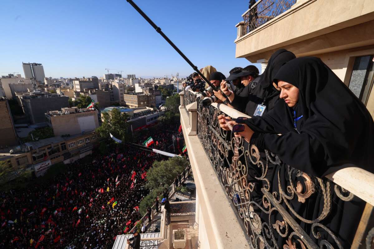 Photographers take pictures of crowds of mourners as they surround the convoy carrying the coffins of Iran's slain supreme leader Ali Khamenei and members of his family during a funeral procession, before he is buried at the Shrine of Imam Reza, Iran's most revered place of worship, in Mashhad on July 9, 2026.