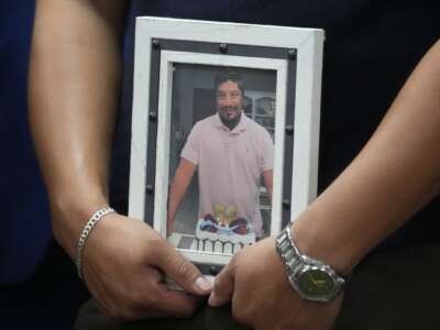 Ronaldo Salgado, son of Lorenzo Salgado Araujo, holds a photo of his father during a news conference about the ICE shooting death in Houston Wednesday, July 8, 2026.