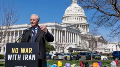 Sen. Chris Van Hollen (D-Maryland) speaks on Capitol Grounds in front of a memorial of 168 pairs of shoes representing those killed in the U.S. strike on an Iranian school, on March 18, 2026 in Washington, D.C.