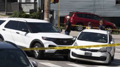 A Kia sedan reportedly driven by the victim of a fatal shooting can be seen with four bullet holes in the windshield at the scene on Pool Street in Biddeford on Monday, July 13, 2026.