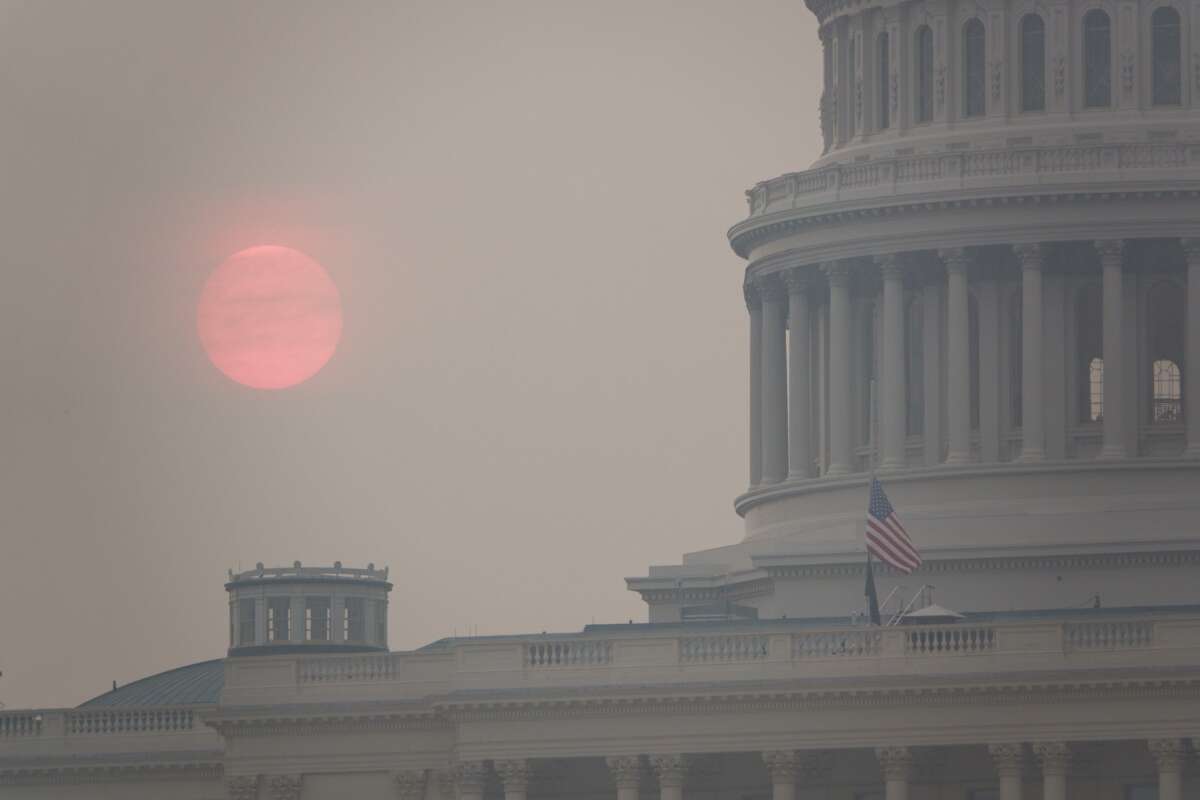 The sun rises behind the U.S. Capitol building during a summer heat wave as smoke from wildfires in Canada fills the air on July 17, 2026 in Washington, D.C.