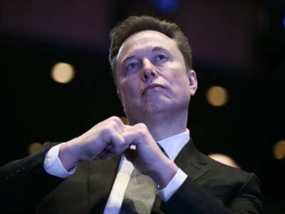 Elon Musk looks on as U.S. President Donald Trump speaks at the U.S.-Saudi Investment Forum at the John F. Kennedy Center for the Performing Arts in Washington, D.C. on November 19, 2025.