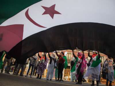 Saharawi women in exile wave a huge flag of Western Sahara during a demonstration calling for the end of the Moroccan occupation and the independence of Western Sahara, in Madrid, Spain, on November 17, 2018.