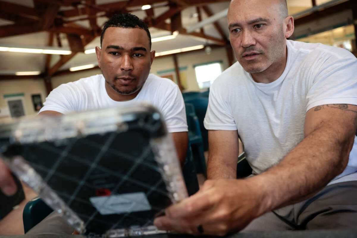 Two incarcerated people demonstrate the different uses of tablet supplied by the Department of Corrections at the Massachusetts Correctional Institution, in Concord, Massachusetts, on May 24, 2024.