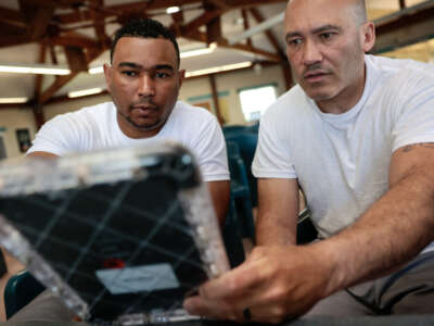Two incarcerated people demonstrate the different uses of tablet supplied by the Department of Corrections at the Massachusetts Correctional Institution, in Concord, Massachusetts, on May 24, 2024.