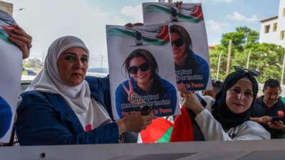 Palestinians and international activists lift portraits of slain Turkish American activist Ayşenur Ezgi Eygi as they arrive for her final farewell at the Rafidia hospital morgue in Nablus in the occupied West Bank, on September 8, 2024.
