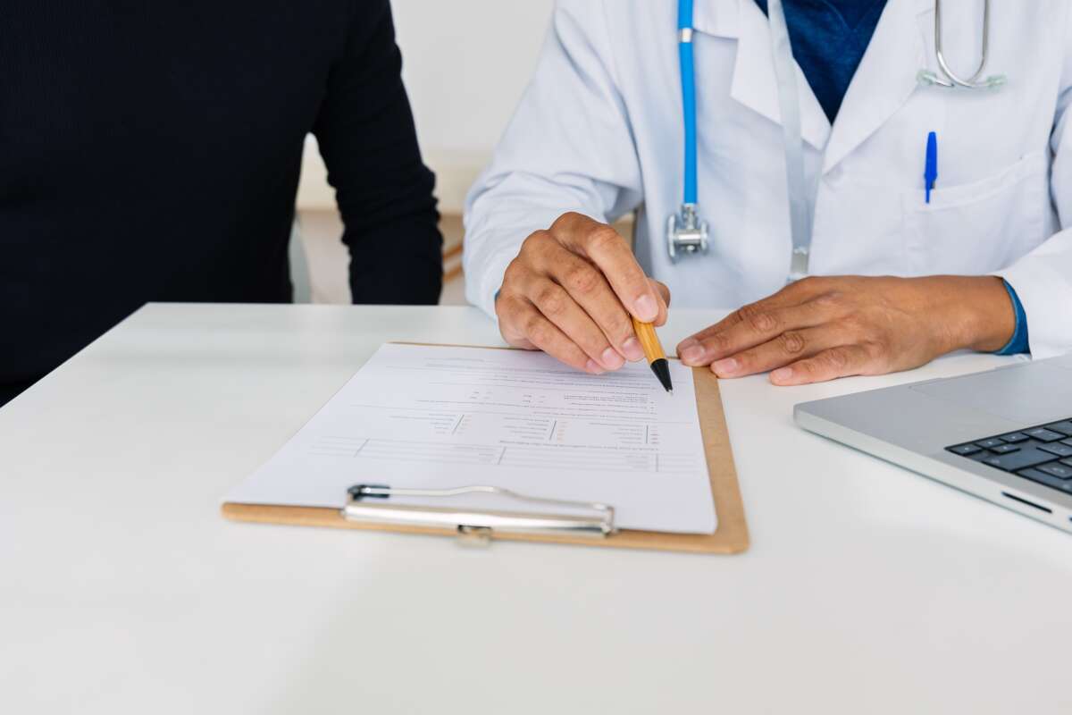 Doctor pointing at medical form for a patient