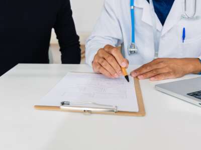 Doctor pointing at medical form for a patient