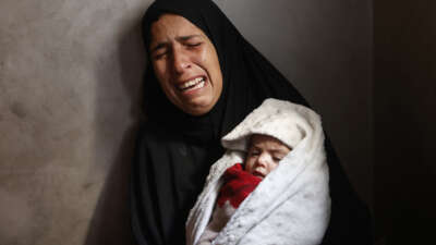 Hiba Abu Jarad, 30, mother of three-month-old Palestinian baby Shatha Abu Jarad, who died of cold weather according to medics, cries while holding Nada, Shatha's twin sister, in Gaza City, Gaza, on January 20, 2026.